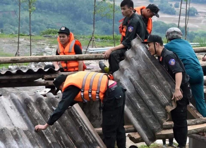 Chiến sĩ CSCĐ giúp dân sửa sang nhà cửa, lợp lại mái nhà sau lũ. (Ảnh:Facebook).