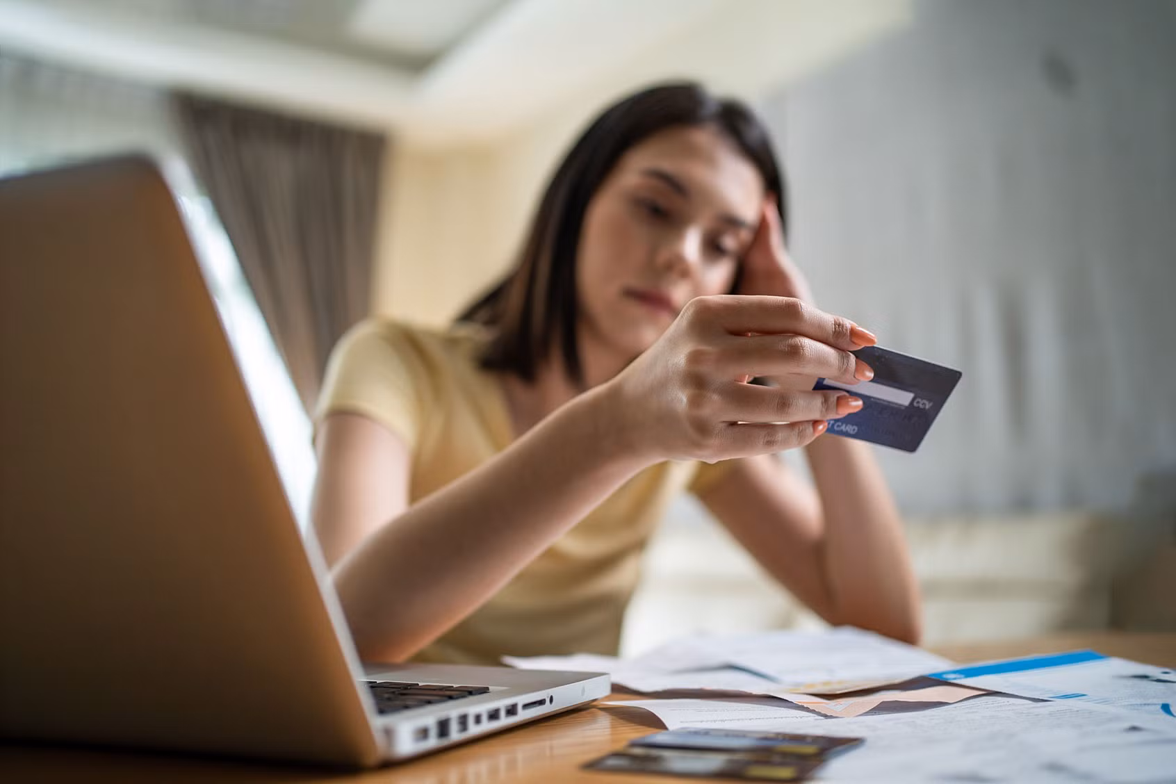 young-woman-stressed-worried-about-finances-looking-at-credit-card-1332045436.jpg