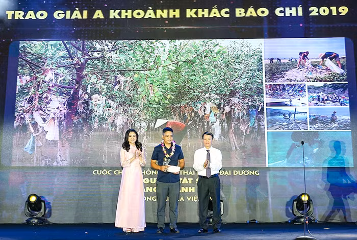 Ông Nguyễn Đức Lợi, Tổng Giám đốc Thông tấn xã Việt Nam cùng MC, BTV Mùi Khánh Ly công bố và trao giải cho tác giả đoạt giải A.