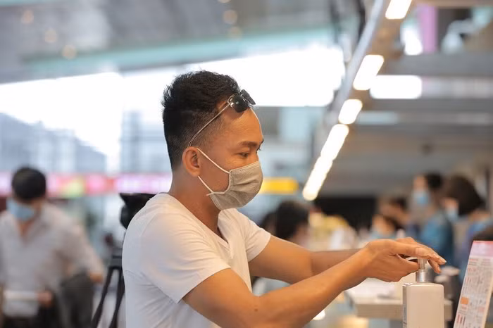 Hành khách rửa tay bằng nước sát khuẩn tại sân bay Vân Đồn