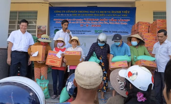 Ông Lê Chí Hùng Việt, đại diện Danh Việt (bìa trái) cùng ông Lê Sanh, Chủ tịch UBND xã Thắng Hải (phải) trao quà cho bà con nghèo