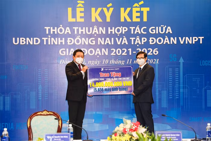 Tổng giám đốc VNPT Huỳnh Quang Liêm (bên trái) và Phó chủ tịch UBND tỉnh Đồng Nai Nguyễn Sơn Hùng (bên phải) thực hiện nghi lễ trao nhận 5.656 máy tính bảng