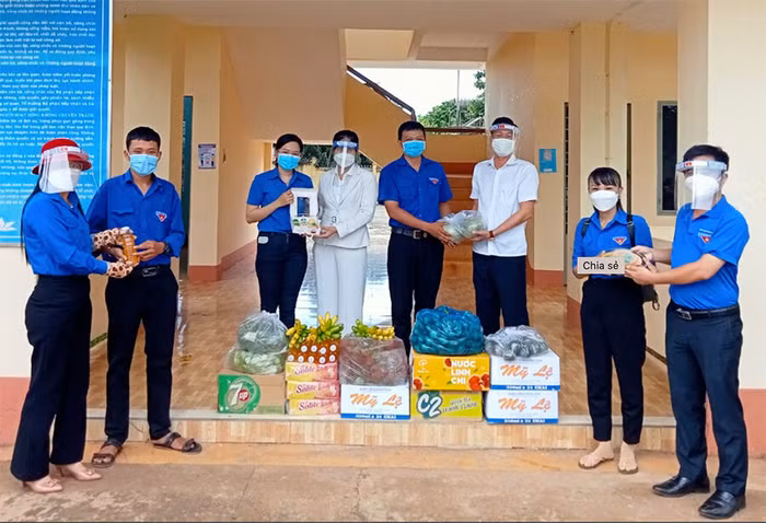 Bí thư Tỉnh Đoàn Trần Quốc Duy (bìa phải) cùng anh Phạm Khắc Học - Giám đốc Công ty TNHH Bất động sản Kiên Cường Phát (thứ 3, phải sang) thăm hỏi, tặng quà các học sinh, sinh viên tình nguyện đi chống dịch tại huyện Lộc Ninh