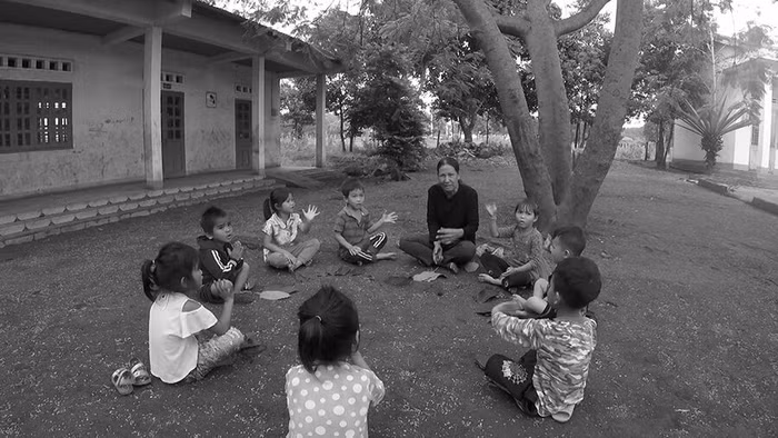 Cô Jel dạy học trò hát dưới gốc cây