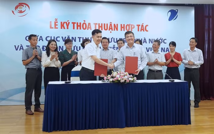 Ông Đặng Thanh Tùng - Cục trưởng Cục Văn thư lưu trữ nhà nước và ông Ngô Diên Hy - Tổng Giám đốc Công ty VNPT-IT đặt bút ký kết thỏa thuận hợp tác dưới sự chứng kiến của lãnh đạo và đại biểu hai bên