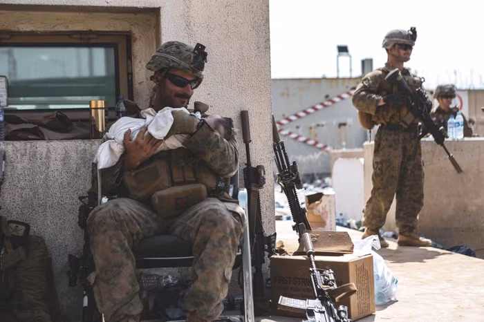 Cảnh quen thuộc, lính Mỹ đưa trẻ em Afghanistan di tản ra khỏi Kabul.