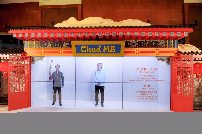 Ông Daniel Zhang (bên trái) trong gian trải nghiệm Cloud Me ở Thượng Hải cùng với ông Thomas Bach (bên phải) trong gian trải nghiệm ở Bắc Kinh được “trình chiếu” theo tỷ lệ 1:1 tại Trung tâm Báo chí Bắc Kinh.