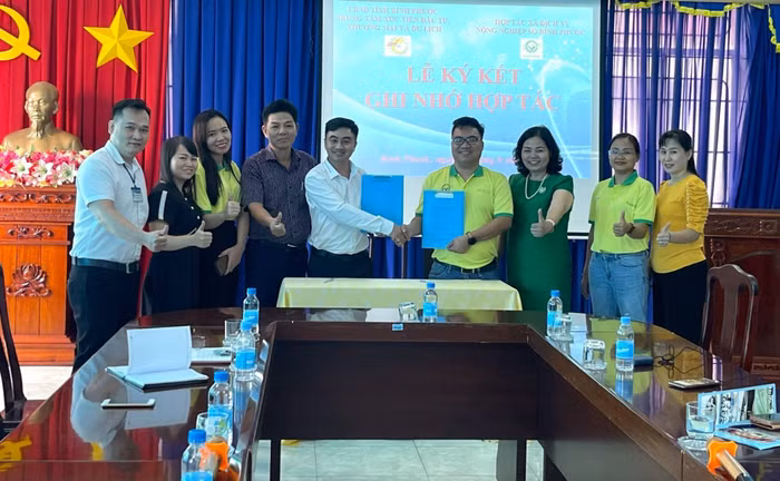 Ông Đặng Dương Minh Hoàng - Giám đốc HTX (thứ 4, phải sang) và ông Trần Quốc Duy, Giám đốc TT XTĐT,TM&amp;DL tỉnh (thứ 5, trái sang) ký kết BBGNHT.