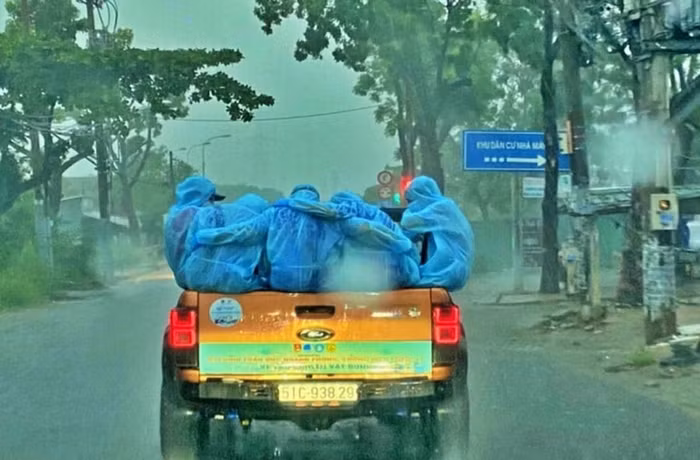 Nhóm tình nguyện viên ôm nhau cho đỡ lạnh dưới cơn mưa nặng hạt. (Ảnh: Mai Xuân Tứ)
