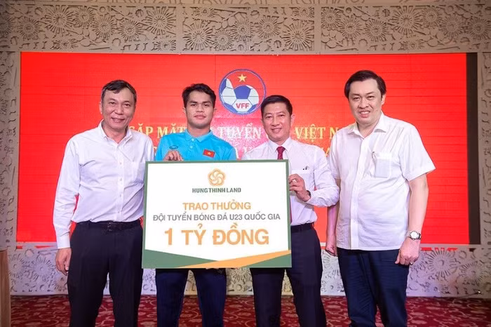 Ông Võ Văn Thư - Phó Tổng Giám đốc Hưng Thịnh Land trao thưởng 1 tỷ đồng cho cầu thủ Dụng Quang Nho - Đội trưởng U23 Việt Nam với sự chứng kiến của ông Trần Quốc Tuấn - Quyền Chủ tịch Liên đoàn Bóng đá Việt Nam (bên trái) và Ông Cao Văn Chóng - Phó Chủ tịch Liên đoàn Bóng đá Việt Nam (bên phải)