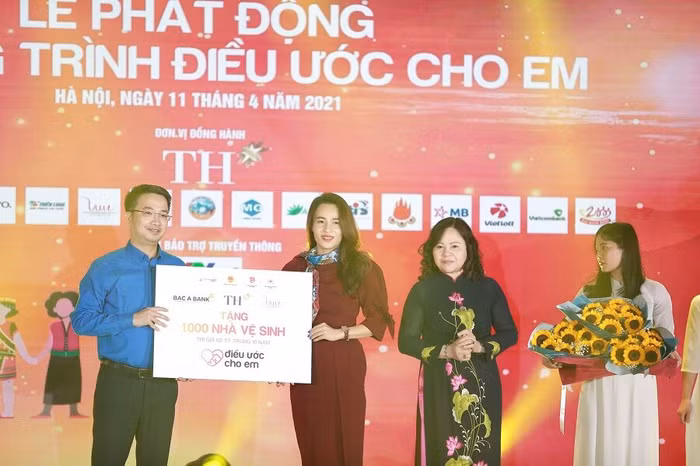 Bà Trần Thị Như Trang, Giám đốc Quỹ Vì Tầm Vóc Việt thay mặt Quỹ, Tập đoàn TH và BAC A BANK trao biển tặng 1.000 nhà vệ sinh cho chương trình Điều ước cho em