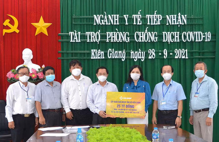 Đại diện Tập đoàn Sun Group (áo xanh) trao bảng tượng trưng hỗ trợ lãnh đạo Sở Y tế Kiên Giang