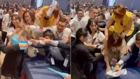 Các nhân viên môi giới giành giật phiếu mua căn hộ. Ảnh cắt từ clip