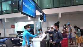 Hành khách làm thủ tục đi máy bay tại quầy vé của Vietnam Airlines