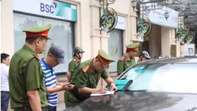 Công an phường Cửa Nam lập biên bản trường hợp xe ô tô dừng đỗ sai quy định. Ảnh: Đăng Chung
