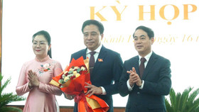 Bí thư Tỉnh ủy Khánh Hòa Nghiêm Xuân Thành tặng hoa chúc mừng tân Chủ tịch UBND tỉnh Nguyễn Khắc Toàn (ở giữa)