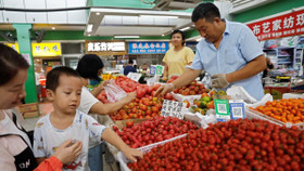 Khách hàng chọn cà chua tại một quầy hàng bên trong chợ buổi sáng ở Bắc Kinh, Trung Quốc