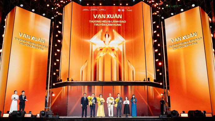 Bà Cao Thị Ngọc Dung (áo dài vàng) nhận bằng khen và cúp vinh danh từ ban tổ chức