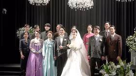 Một hình ảnh từ bộ phim truyền hình Reborn Rich (2022) cho thấy cảnh các thành viên gia đình chụp ảnh cùng cặp đôi sau lễ cưới