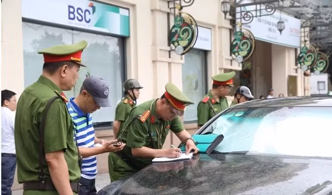 Công an phường Cửa Nam lập biên bản trường hợp xe ô tô dừng đỗ sai quy định. Ảnh: Đăng Chung