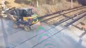 Mắc kẹt giữa đường ray, xe đào đất bị tàu hỏa húc bay 