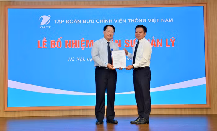Ông Huỳnh Quang Liêm, Tổng giám đốc Tập đoàn VNPT trao quyết định bổ nhiệm cho ông Nguyễn Văn Tấn (bên trái)