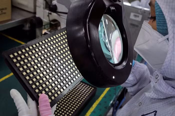 Một công nhân kiểm tra chip bán dẫn tại nhà máy của lắp ráp chip Unisem ở Ipoh, Malaysia