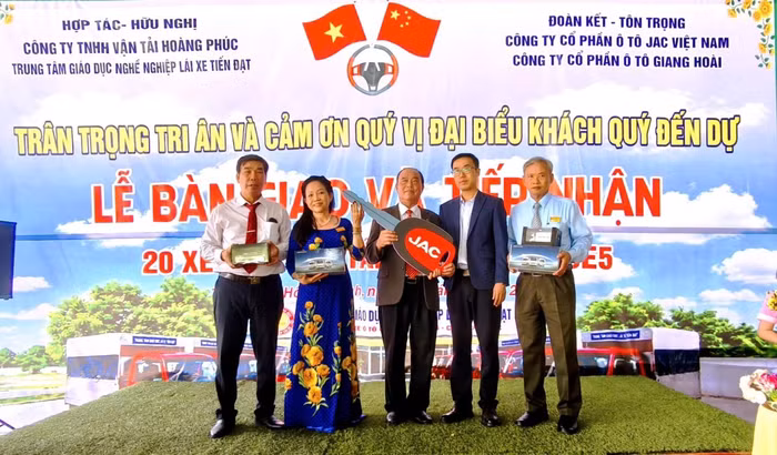 Ông Nguyễn Văn Hạnh, Giám đốc Trung tâm Lái xe Tiến Đạt (giữa) nhận bàn giao 20 xe tải H360E5 từ JAC Việt Nam