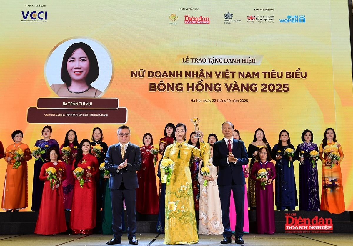 Ủy viên Trung ương Đảng, Phó Trưởng Ban Tuyên giáo và Dân vận Trung ương Lê Quốc Minh và Phó Chủ tịch VCCI Hoàng Quang Phòng trao tặng danh hiệu Bông Hồng Vàng cho nữ doanh nhân Trần Thị Vui - Giám đốc Công ty TNHH MTV sản xuất Tinh dầu Kim Vui. Ảnh: Diễn đàn Doanh nghiệp vui.jpg