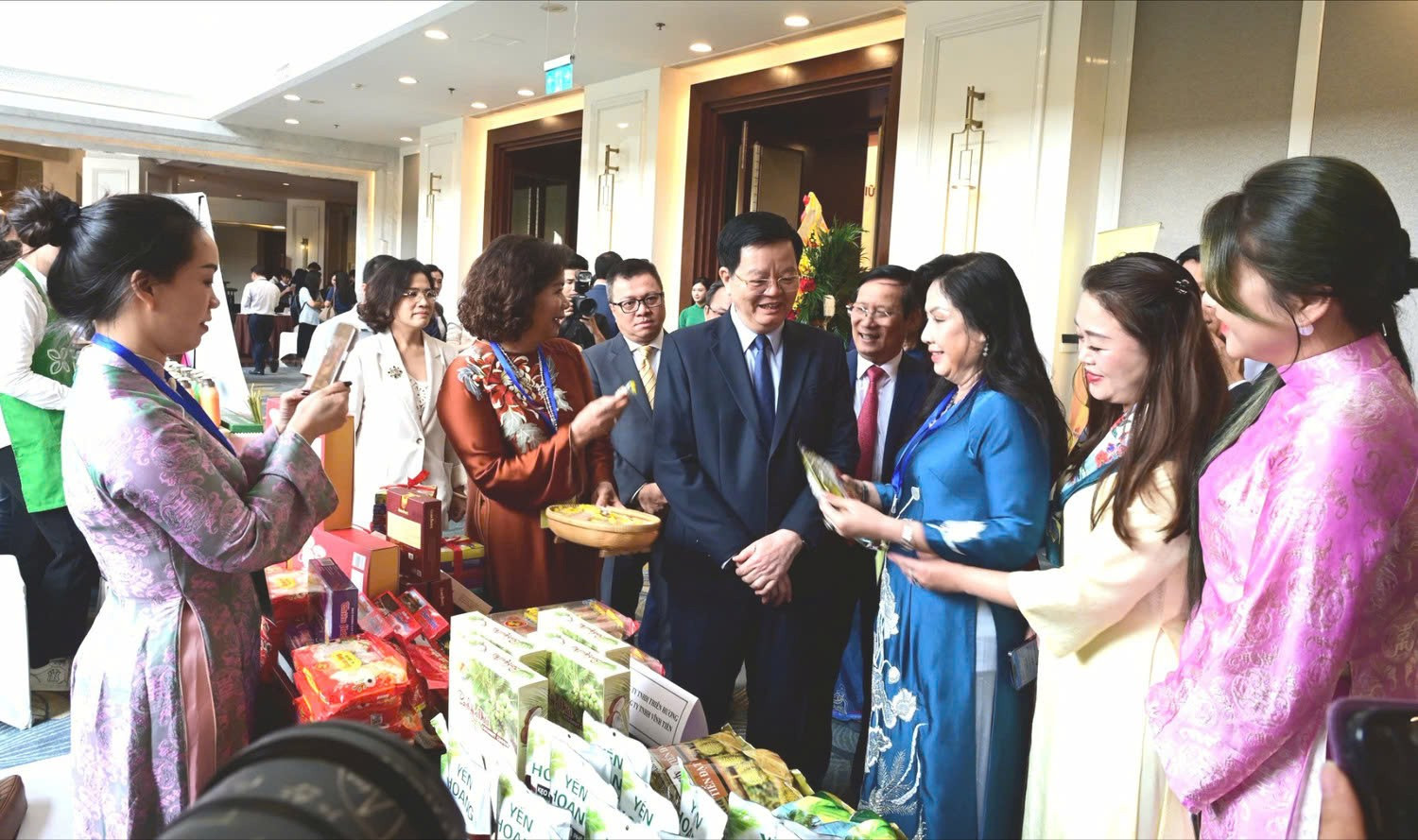 Ông Mai Văn Chính - Ủy viên Trung ương Đảng, Phó Thủ tướng Chính phủ, ông Phạm Tấn Công - nguyên Chủ tịch Liên đoàn Thương mại và Công nghiệp Việt Nam (VCCI), bà Nguyễn Thị Thu Thủy - Phó Chủ tịch thường trực Hiệp hội Phát triển Hàng tiêu dùng Việt Nam (VACOD) và các đại biểu tham quan gian hàng của Công ty TNHH Vĩnh Tiến