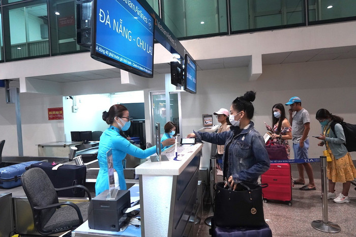 Hành khách làm thủ tục đi máy bay tại quầy vé của Vietnam Airlines