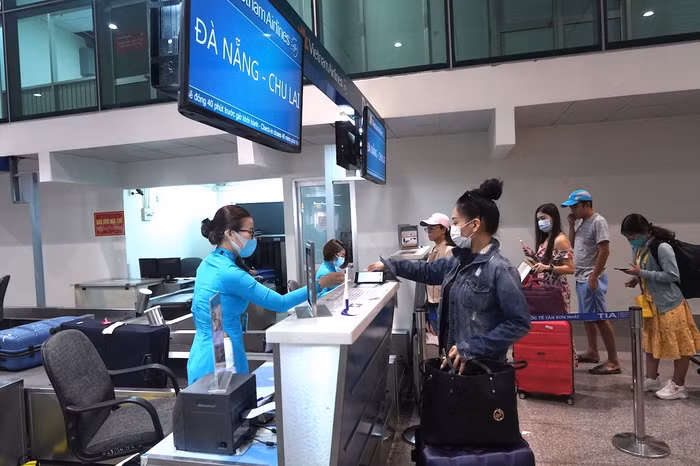 Hành khách làm thủ tục đi máy bay tại quầy vé của Vietnam Airlines