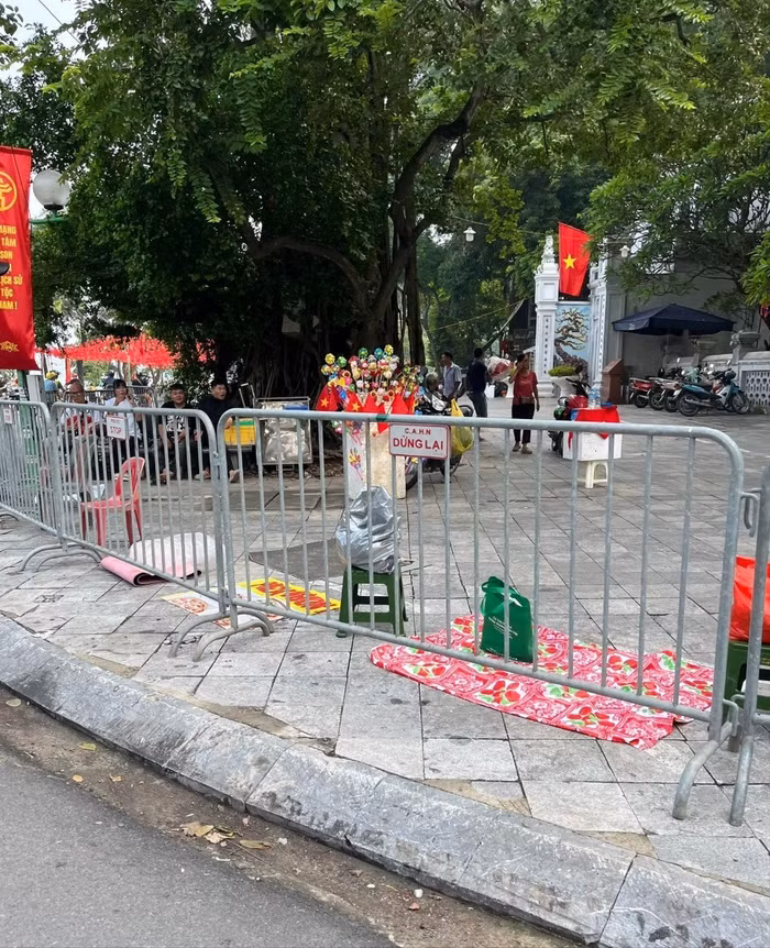 Người dân mang theo ghế nhựa, bạt cùng nhiều vật dụng khác để “đánh dấu” vị trí cho riêng mình