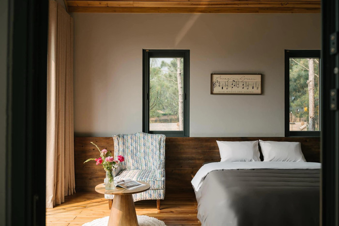 Không gian phòng ngủ cũng được thiết kế ấm cúng, với tầm nhìn ra rừng thông đầy thơ mộng