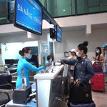Hành khách làm thủ tục đi máy bay tại quầy vé của Vietnam Airlines