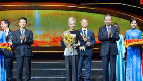 Bà Nguyễn Thị Dịu, Tổng giám đốc One Mount Group nhận biểu trưng chúc mừng nhận nhiệm vụ của Tổng Bí thư Tô Lâm và hoa chúc mừng của Bộ trưởng Bộ Thông tin và Truyền thông Nguyễn Mạnh Hùng